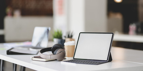 Wall Mural - blank screen tablet with on-ear headphones and office supplies on white table