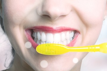 Wall Mural - Female brushing teeth with yellow brush, close up