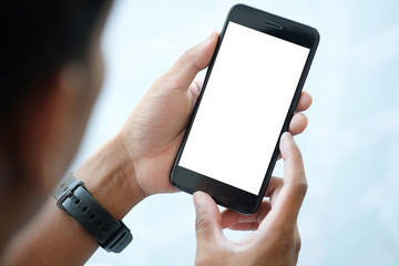 Cropped shot view of man hands holding smart phone with blank copy space screen for your text message or information content, female reading text message on cell telephone during in urban setting. 