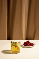 Wall Mural - Cocktail drink with pomegranate seeds on white table