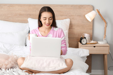 Poster - Morning of beautiful young woman with laptop and cup of coffee in bedroom