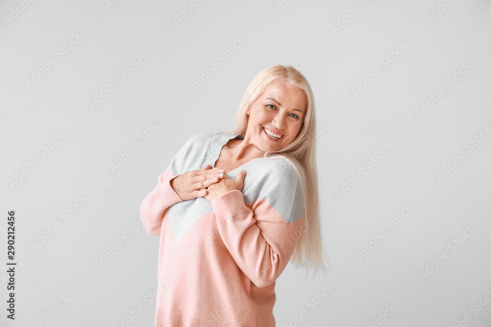 Happy mature woman on grey background