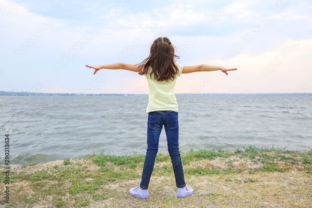 Cute little girl on river bank