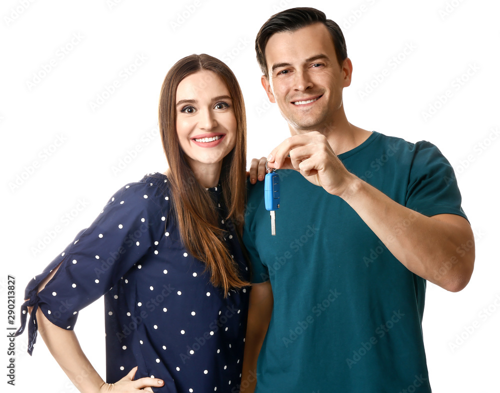 Happy couple with key from their new car on white background