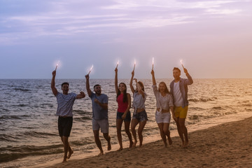 Poster - Happy friends with sparklers on sea beach at resort