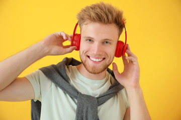 Sticker - Handsome young man listening to music on color background