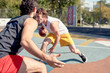 © Sergey - Photo of young sports men playing basketball on playground on summer day.