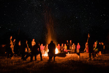 Beautiful Scenery Of Night Vision. Bonfire Around People. Basking By The Fire At Night. The Concept Of Outdoor Activities.