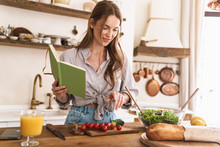 Pretty Lady Indoors At The Kitchen Cooking Holding Notebook.