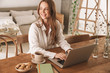 © Drobot Dean - Business woman sit indoors in office using laptop computer.