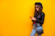 Profile Side Photo Of Cute Sweet Cheerful Girl Use Her Cellphone Share Post Social Network Read Feednews Wear Good Black Outfit Denim Jeans Isolated Over Yellow Color Background