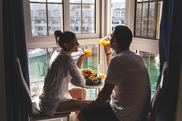 Happy young Couple Enjoying Breakfast .on the terrace at the marina. Relationship and lifestyle concept.