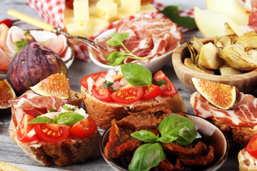 Italian antipasti wine snacks set. Cheese variety, Mediterranean olives, Prosciutto di Parma, tomatoes, artichokes