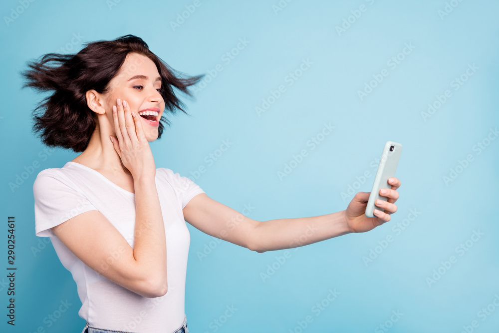 Close-up profile side view portrait of nice attractive lovely amazed cheerful cheery dreamy girl taking selfie having fun isolated on bright vivid shine vibrant blue turquoise color background - obrazy, fototapety, plakaty 