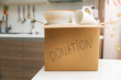 © ronstik - donate household items - box with tableware for donation on kitchen table