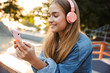 © Drobot Dean - Positive young teenage girl outside in park holding mobile phone.