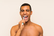 Young handsome brunette man brushing his teeth
