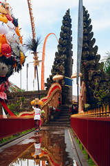 Wall Mural - Woman in traditional Balinese costume carry religious offering to Pura Ulun Danu Batur temple in Kintamani for hindu ceremony. Religion, art and culture of Indonesia. Popular Bali travel destination