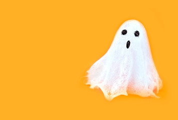 Halloween white spooky ghost spirit on orange backgrounds. Minimal concept scary autumn.