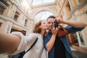 Wall Mural - Young hipster couple in love makes selfie portrait in the city. Travel concept. Summer tourism