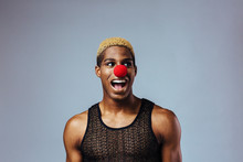 Portrait Of A Young Man Laughing  In Studio With Red Clown Nose