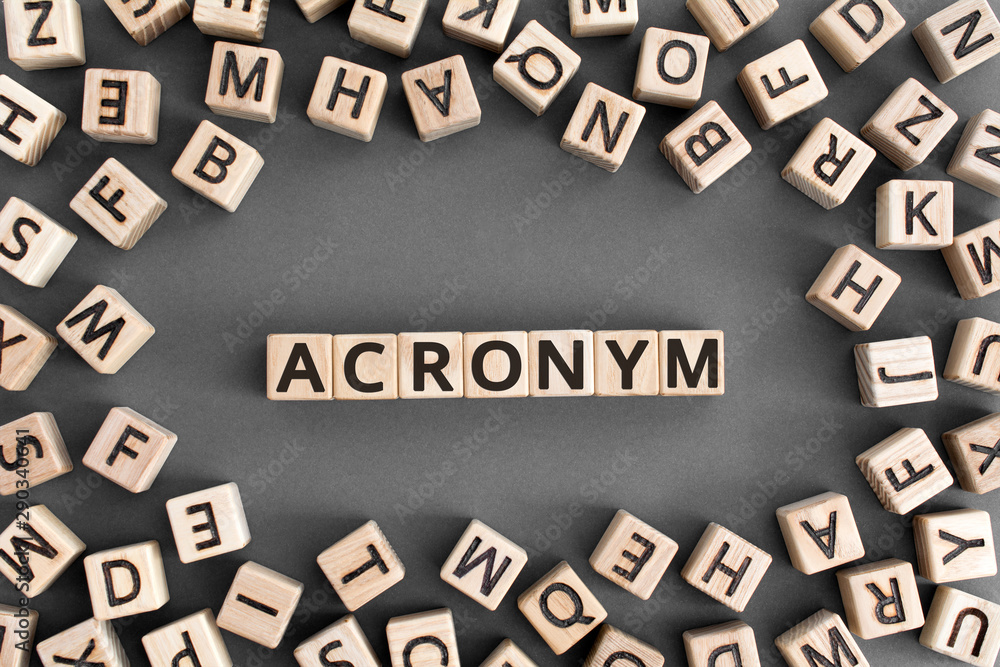 acronym - word from wooden blocks with letters, use of acronyms in the modern world abbreviation concept, random letters around, top view on wooden background - obrazy, fototapety, plakaty 
