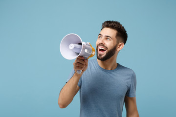 Wall Mural - Young cheerful funny man in casual clothes posing isolated on blue wall background, studio portrait. People sincere emotions lifestyle concept. Mock up copy space. Scream in megaphone, looking aside.