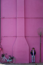 Boy Standing Against A Pink Wall