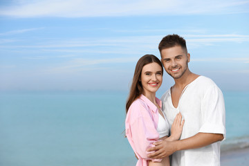 Canvas Print - Young woman in bikini with her boyfriend on beach, space for text. Lovely couple