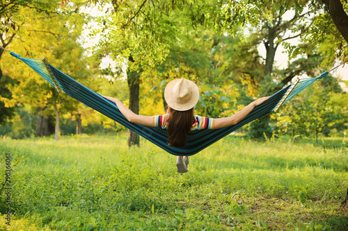Young woman resting in comfortable hammock at green garden Tableau sur Toile