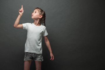 Kid girl wearing white t-shirt with space for your logo or design over gray background