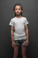 Kid girl wearing white t-shirt with space for your logo or design over gray background