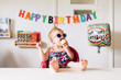© Jessica Byrum/Stocksy - Cool toddler girl eating a purple cupcake on her second birthday.