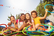 © Sergey Novikov - Happy laughing kids sit with hula rings in garden