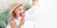 Kid Is Eating Ice Cream. Happy Little Girl Is Enjoying Italian Gelato In Town. Cute Child In Straw Hat Is Tasting Delicious Street Food In Summer Travel Outdoors. Light Background, Free Space For Text