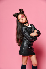 Wall Mural - hipster punk girl - dressed in a leather jacket and skirt, with a funny hairstyle and a makeup painted star on her face, folded her arms across her chest and looks behind her