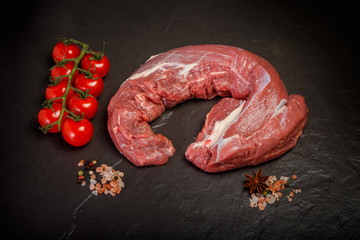 Wall Mural - top view on big piece of raw meat with spices and tomatoes