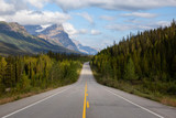Fototapeta Góry - Scenic road in the Canadian Rockies during a vibrant sunny and cloudy summer morning. Taken in Icefields Parkway, Banff National Park, Alberta, Canada.