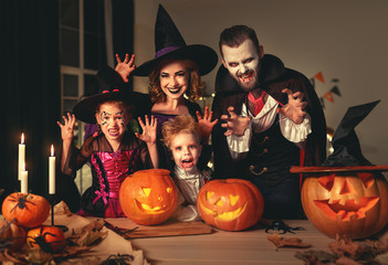 Canvas Print - happy family mother father and children in costumes and makeup on  Halloween