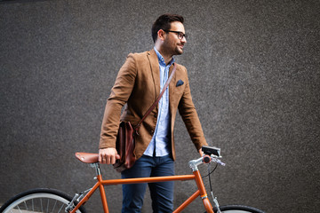 Wall Mural - Happy young stylish businessman going to work by bike