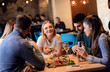 © Zoran Zeremski - Group of young friends having fun in restaurant, talking and laughing while dining at table.