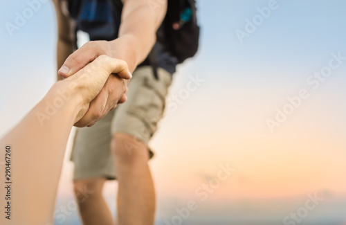 Cuadros en Lienzo Hikers climbing mountain, helping, giving hand to friend.