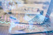 © peshkova - Financial market graph hologram and personal computer on background. Double exposure. Concept of forex.