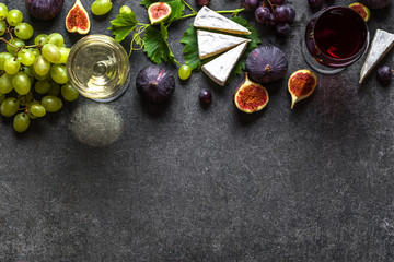 Wall Mural - Glasses of red and white wine with cheese, grapes and figs