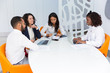 © Mangostar - Diverse creative group enjoying brainstorming set. Business man and women meeting at conference table, using laptops, talking, writing, smiling. Brainstorming or teamwork concept