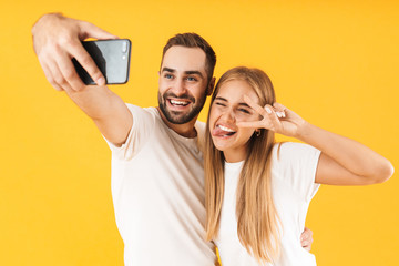 Poster - Image of happy couple showing peace sign while taking selfie photo