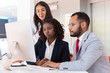 © Mangostar - Business team watching project presentation on desktop together. Diverse business man and women sitting at table, using computer, looking at monitor. Computer for business concept