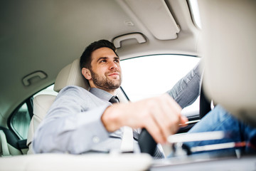 Wall Mural - Businessman with shirt and tie sitting in brand new car, driving.