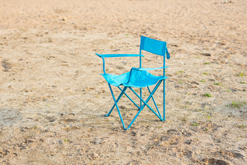 End of season, vacation and loneliness concept - Blue chair on the beach