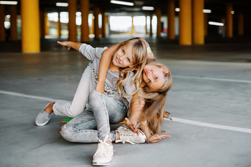 Two beautiful girls having fun and playing in the parking lot. Street photo shoot